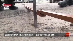 У Львові патрульні поліцейські лінійкою вимірюють глибину ям на дорогах