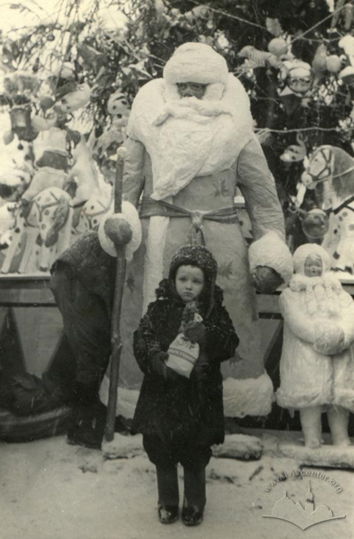 Дитина на фоні іграшкових фігур біля ялинки на проспекті Свободи у Львові, 1950-ті роки