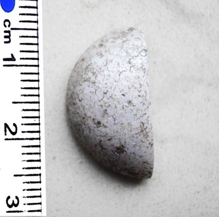 Частина жетона з білого пастового скла, який використовували для римських настільних ігор