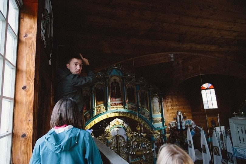 Отець Роман Гром показує відвідувачам криївку в церкві (фото Альони Малашиної)
