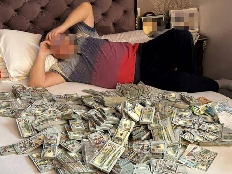 Володимир Крупа біля стосу грошей. Фото ДБР