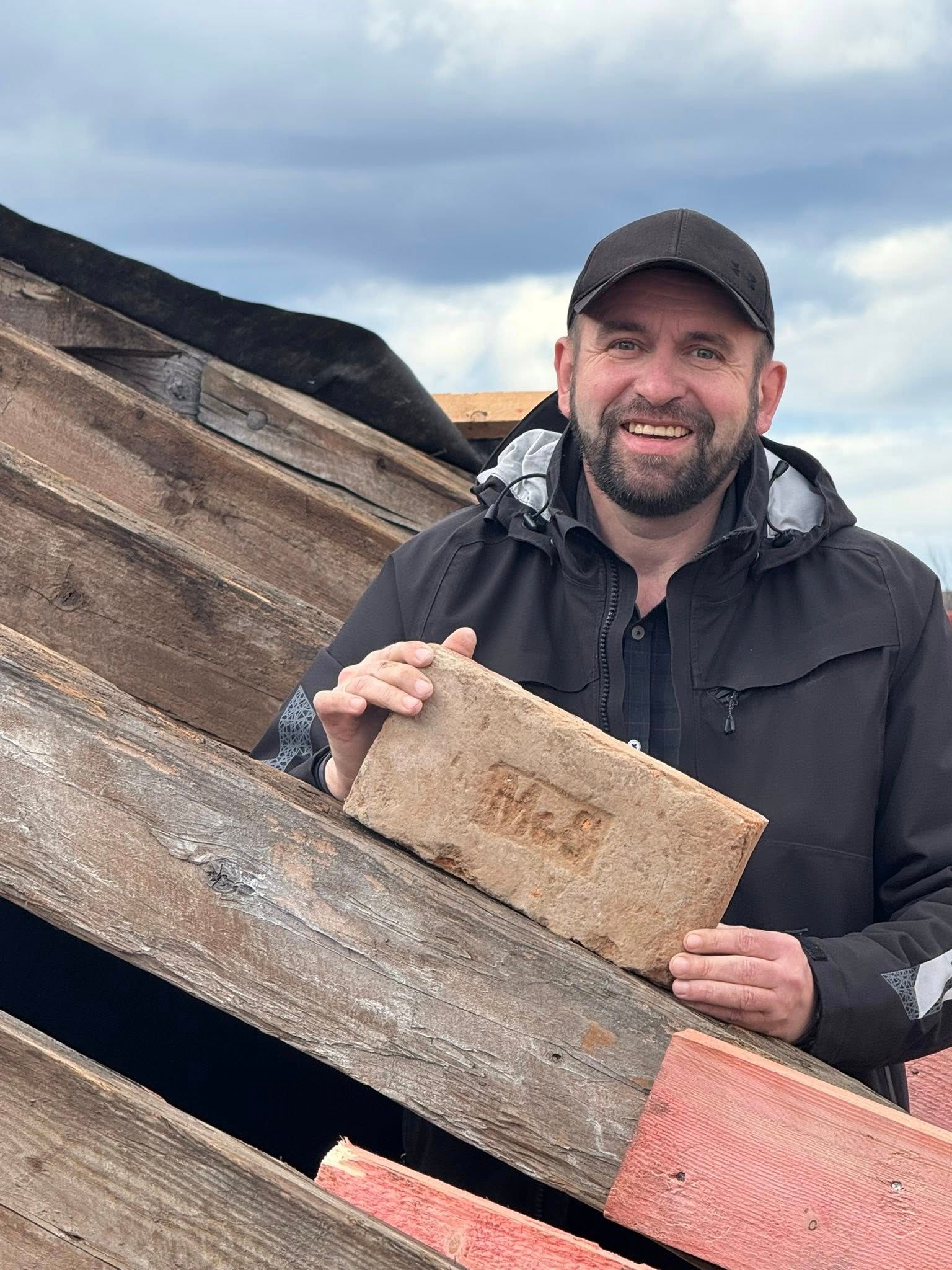 Директор краєзнавчого музею Микола Закусов тримає цеглу з клеймом