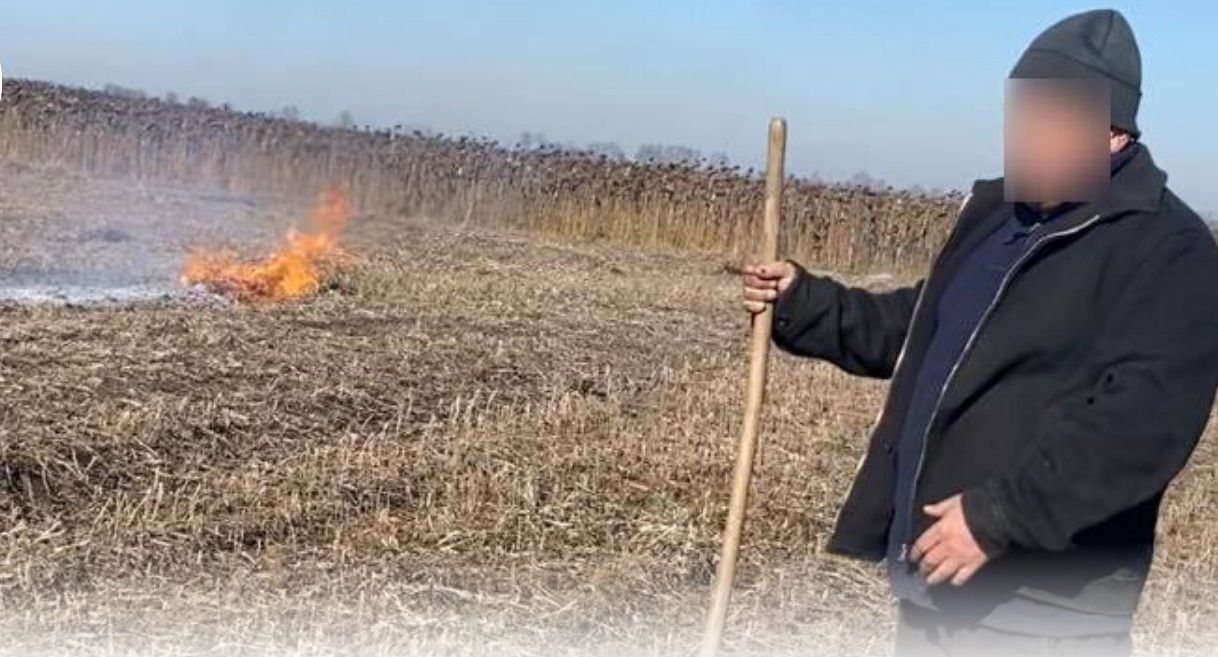 Чоловік палив стерню на полі