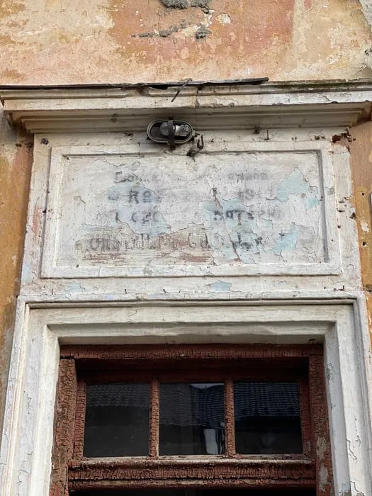 Історична таблиця з втраченим написом над дверима